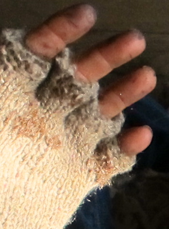 Detail of repairs made to the palm of the workman's glove after a screw went awry.